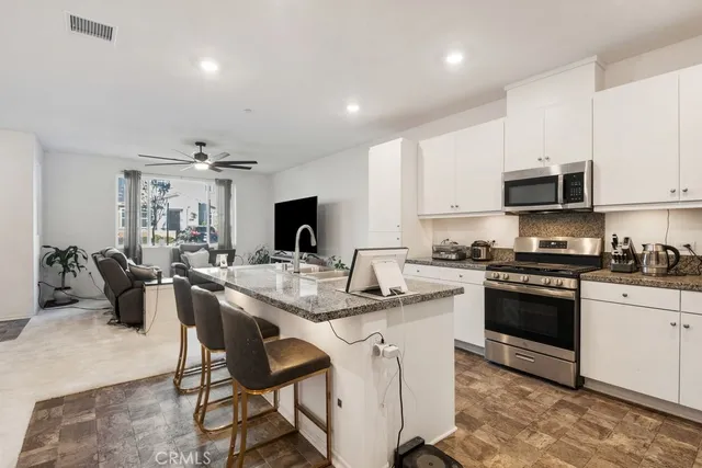a kitchen with sink a microwave and cabinets
