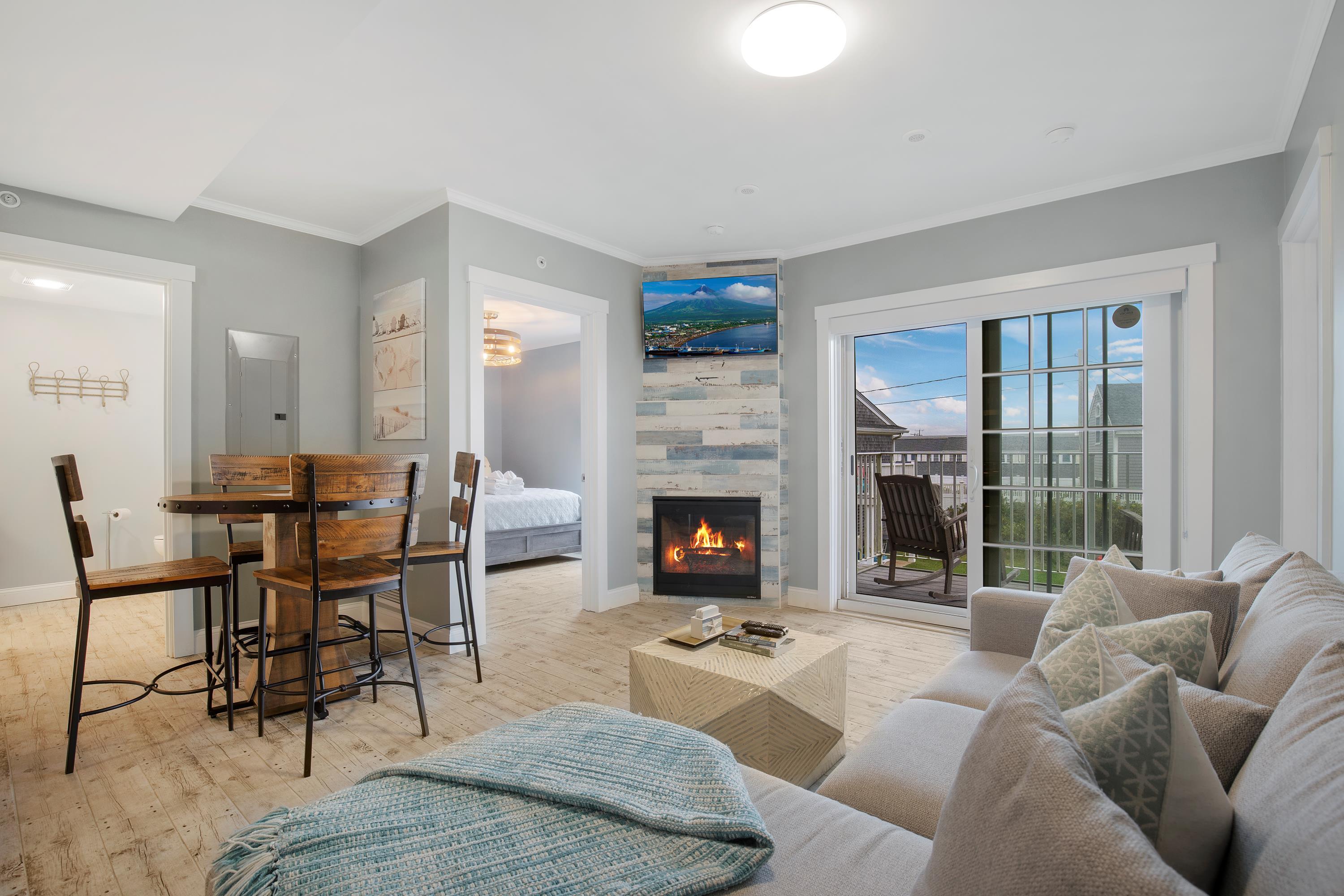 405 Old Wharf Road, Unit B204 Dennis, MA 02639 - Photo 7 of 33 a living room with furniture a fireplace and a floor to ceiling window