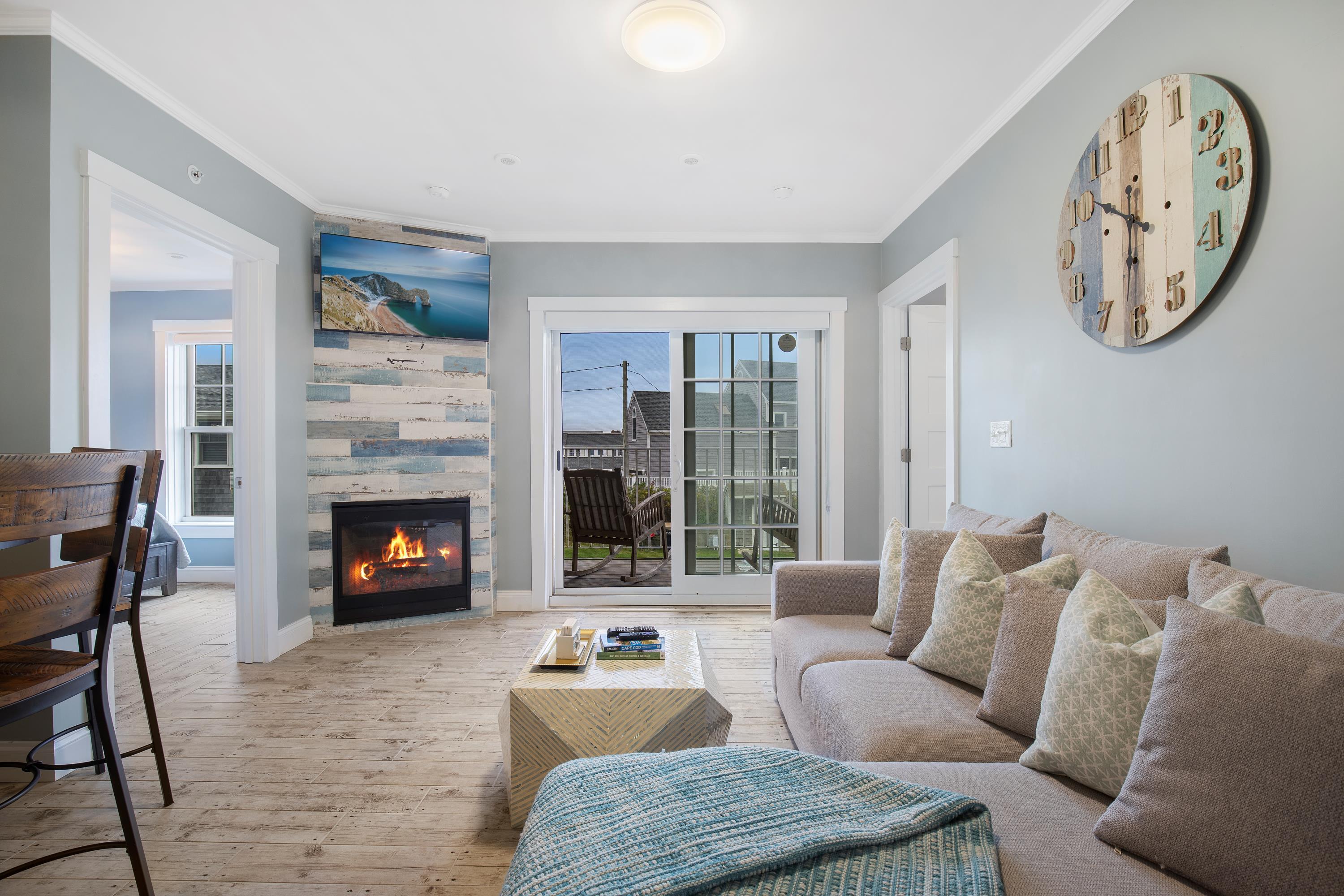 405 Old Wharf Road, Unit B204 Dennis, MA 02639 - Photo 8 of 33 a living room with furniture a clock and a fireplace