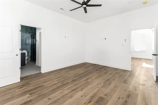 a view of a room with wooden floor and a ceiling fan