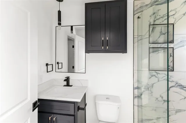 a bathroom with a sink a toilet and shower