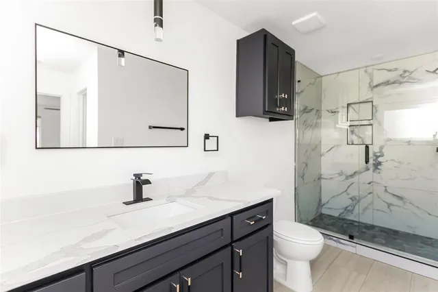 a bathroom with a sink toilet a mirror and shower