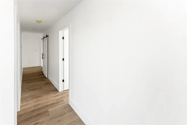 a view of a hallway with wooden floor