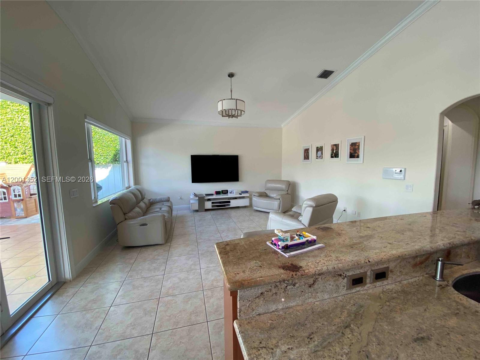 14302 Southwest 15th Street Miami, FL 33184 - Photo 20 of 63 a living room with furniture and a flat screen tv