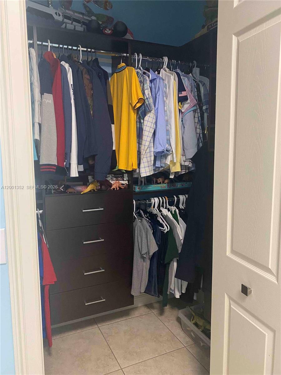 14302 Southwest 15th Street Miami, FL 33184 - Photo 31 of 63 a view of walk in closet with clothes and shoes