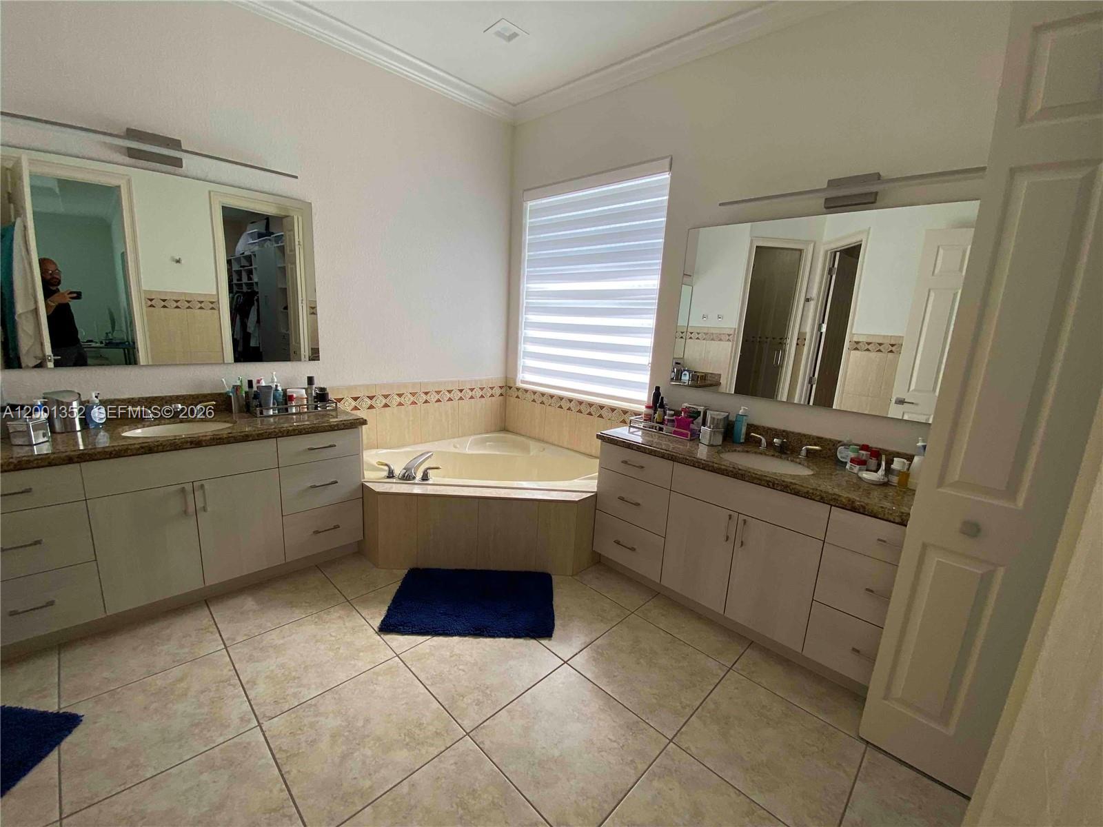 14302 Southwest 15th Street Miami, FL 33184 - Photo 60 of 63 a bathroom with a sink a mirror and a bathtub