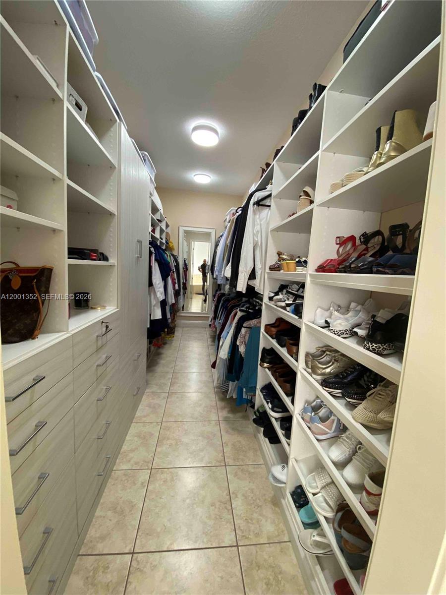 14302 Southwest 15th Street Miami, FL 33184 - Photo 62 of 63 a view of walk in closet with clothes and shoes