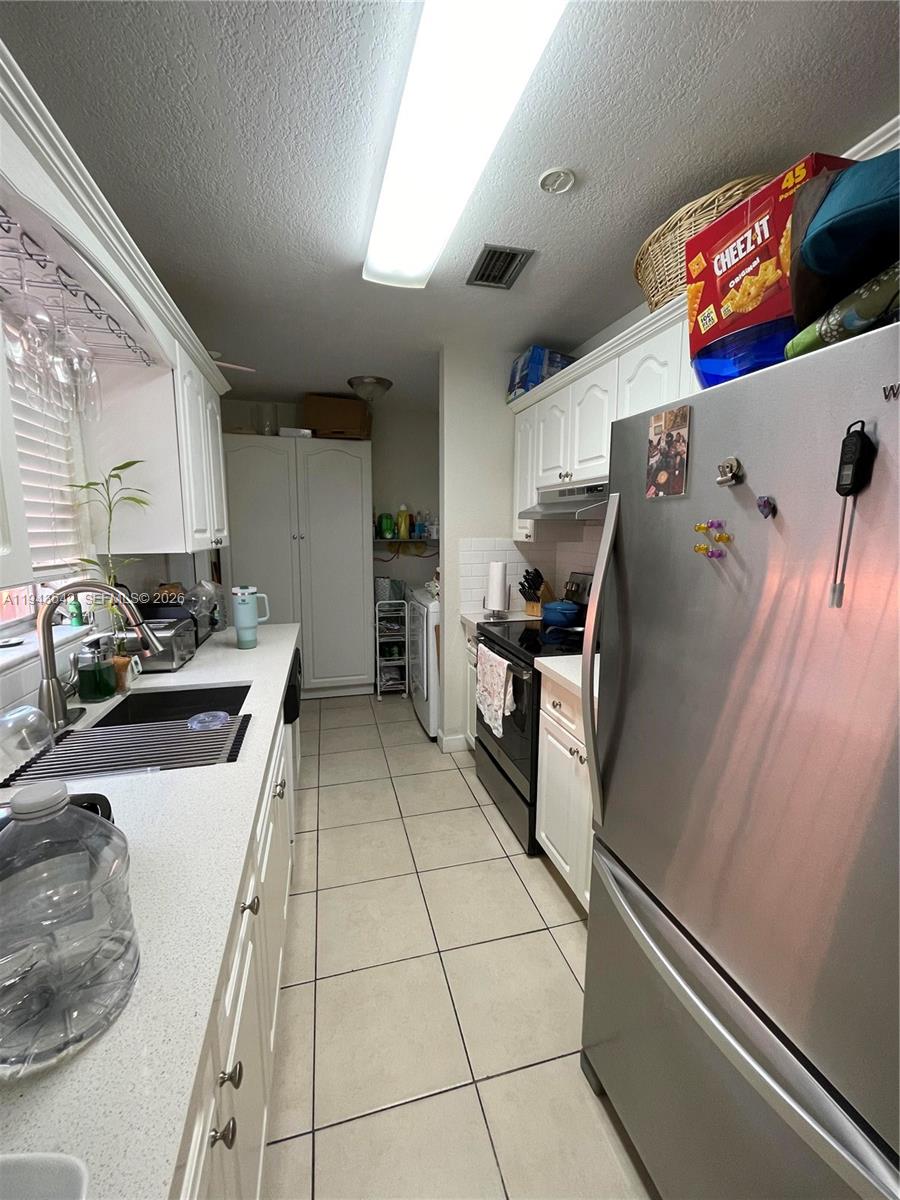 3270 Southwest 7th Street Miami, FL 33135 - Photo 17 of 25 a kitchen with stainless steel appliances granite countertop a refrigerator a stove and a sink