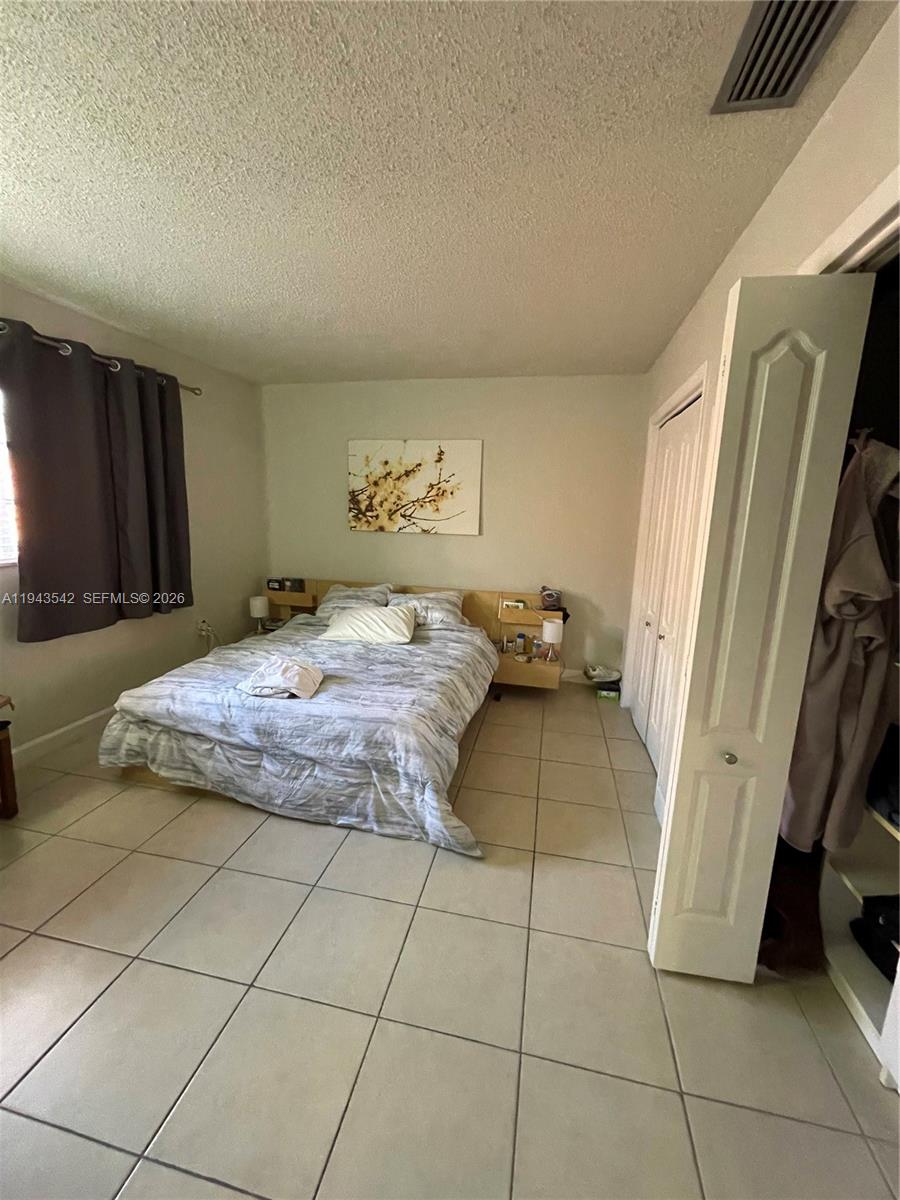 3270 Southwest 7th Street Miami, FL 33135 - Photo 18 of 25 a bedroom with a bed and a refrigerator