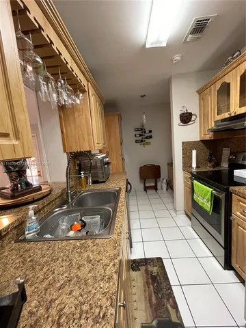a kitchen with stainless steel appliances granite countertop a sink and a stove