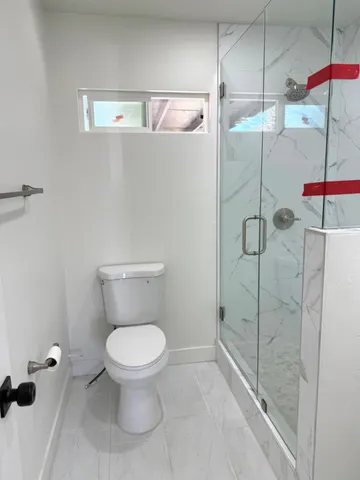 a bathroom with a toilet and a shower