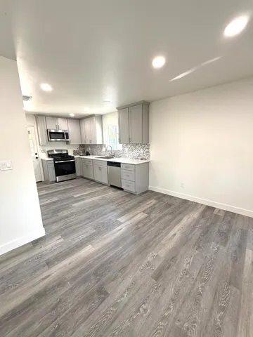 a view of a kitchen with furniture and wooden floor