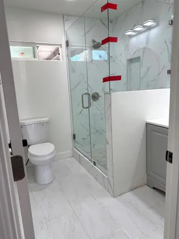 a bathroom with a toilet and a shower