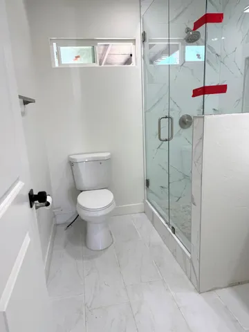 a bathroom with a toilet and a shower