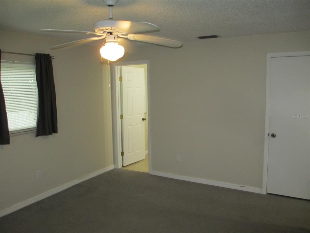 4469 Keyes Avenue Spring Hill, FL 34606 - Photo 12 of 27 an empty room with a mirror and a fan