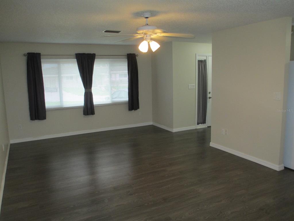 4469 Keyes Avenue Spring Hill, FL 34606 - Photo 6 of 27 a view of an empty room with wooden floor and a window