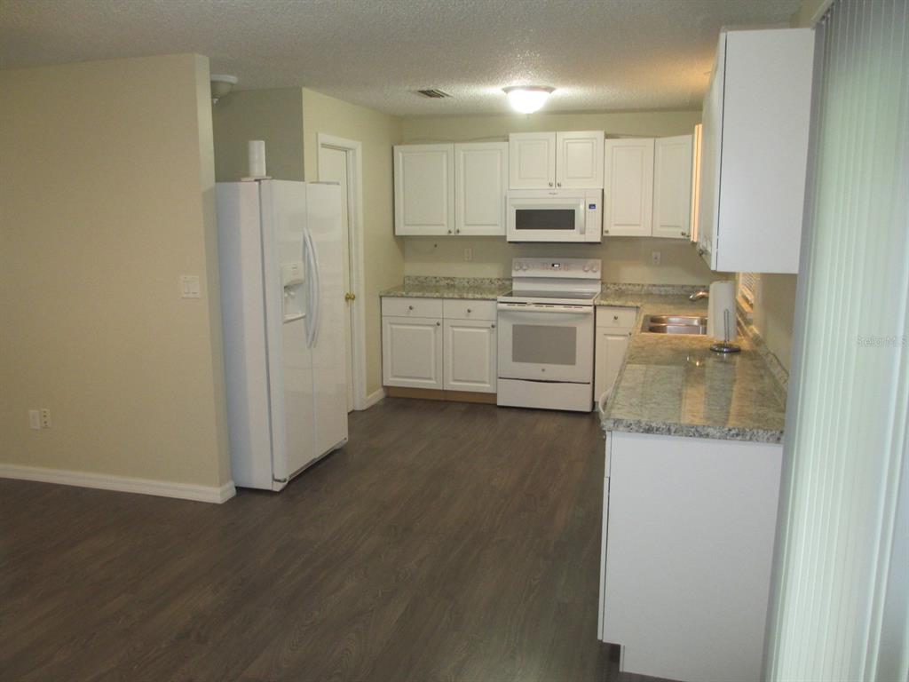4469 Keyes Avenue Spring Hill, FL 34606 - Photo 8 of 27 a kitchen with stainless steel appliances granite countertop a refrigerator and a stove