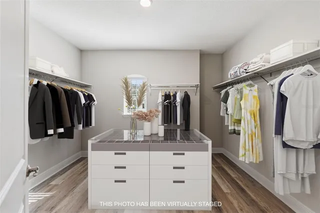 a view of walk in closet with clothes and shoes