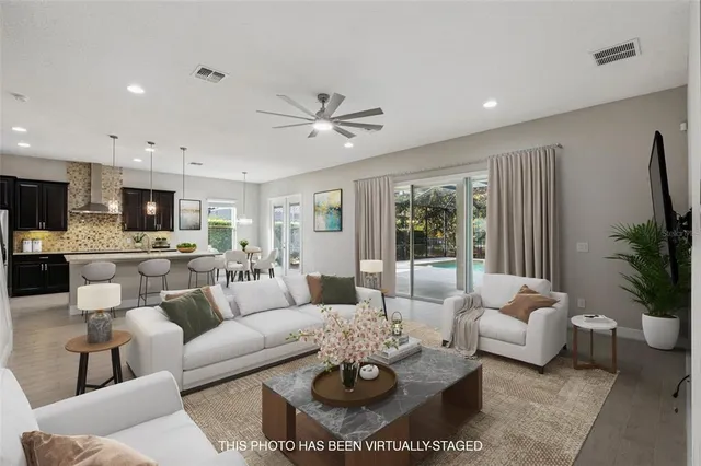 a living room with furniture potted plant and a large window