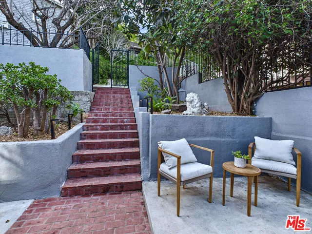 a view of patio with table and chairs and potted plants