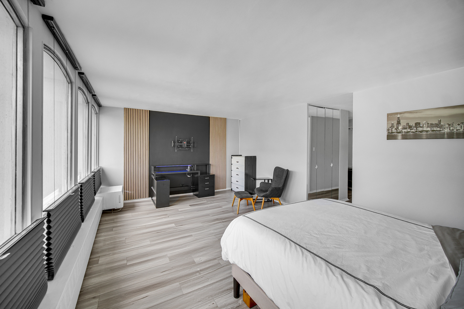 1401 East 55th Street, Unit 313N Chicago, IL 60615 - Photo 6 of 20 a bed room with a bed a mirror and furniture