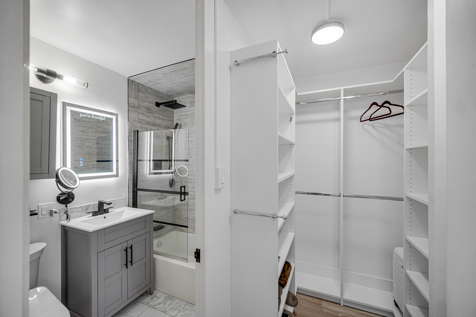 1401 East 55th Street, Unit 313N Chicago, IL 60615 - Photo 7 of 20 a bathroom with a double vanity sink a toilet and shower