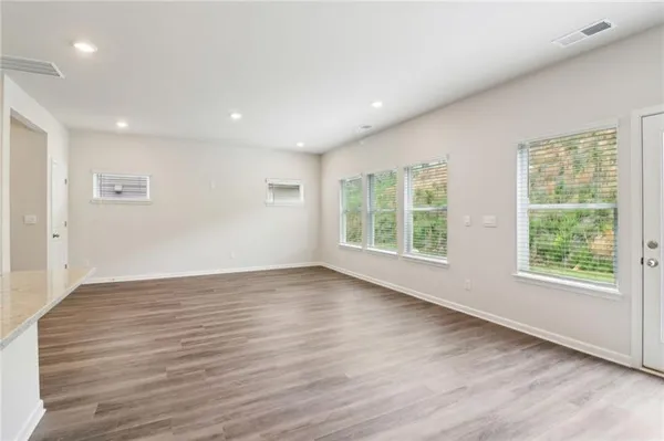 an empty room with wooden floor and windows