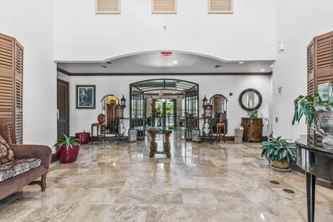 a living room with furniture a clock on wall and a large window