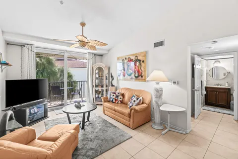a living room with furniture a flat screen tv and a floor to ceiling window