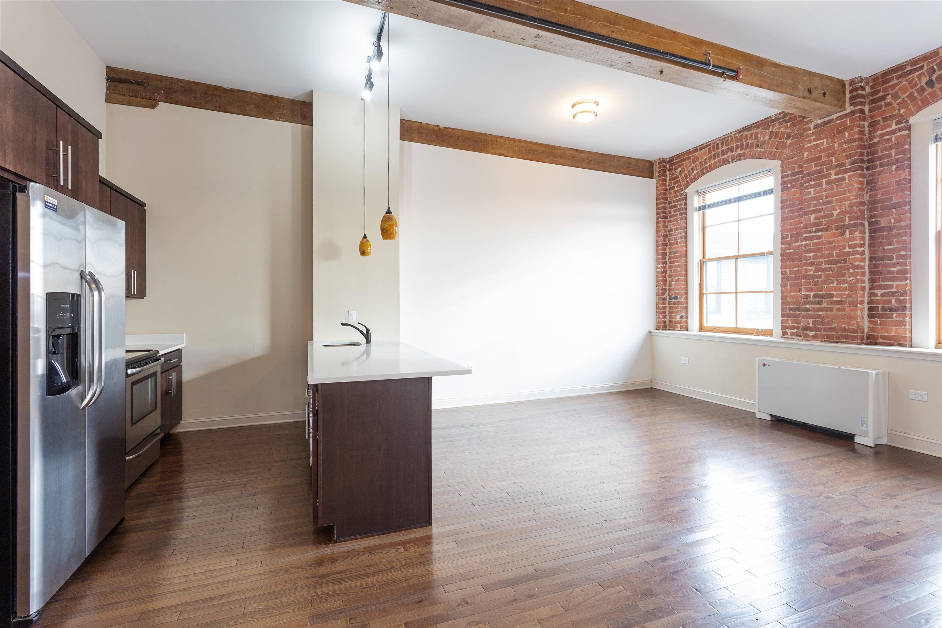 154 Ave East, Unit A501 Bayonne, NJ 07002 - Photo 2 of 19 a view of an empty room with a window and wooden floor