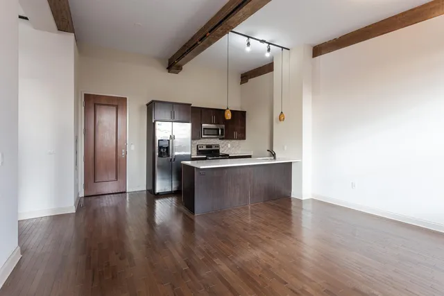 a view of kitchen with sink refrigerator and microwave