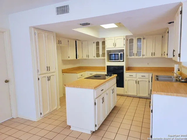 a kitchen with cabinets and wooden floor