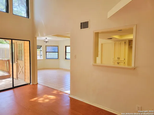 a view of a hallway with wooden floor and windows