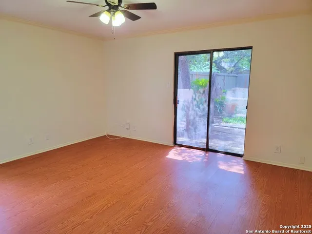 an empty room with fan and windows
