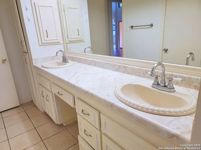 a bathroom with a double vanity sink and a mirror