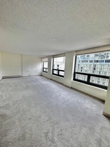 a view of an empty room with a fireplace and windows