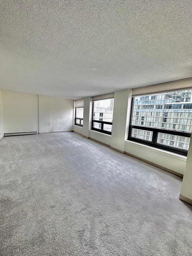 440 North Wabash Avenue, Unit 1704 Chicago, IL 60611 - Photo 2 of 6 a view of an empty room with a fireplace and windows