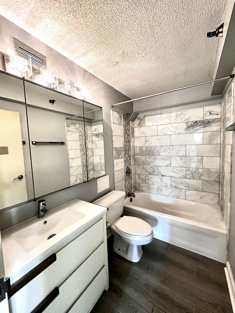 440 North Wabash Avenue, Unit 1704 Chicago, IL 60611 - Photo 5 of 6 a bathroom with a double vanity sink toilet mirror and tub