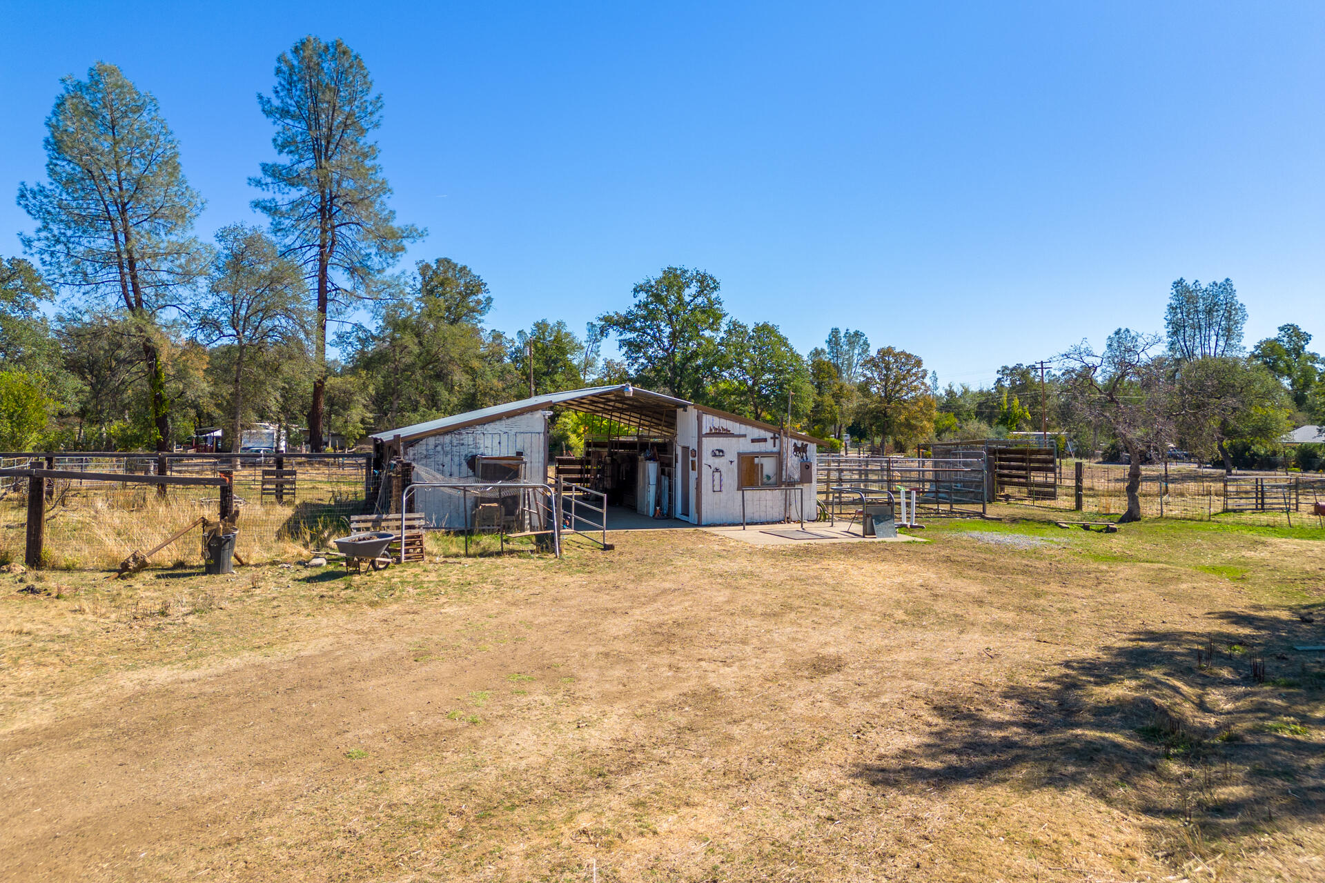 12141 Cinder Road Redding, CA 96003 - Photo 21 of 23 a backyard of a house with table and chairs under an umbrella