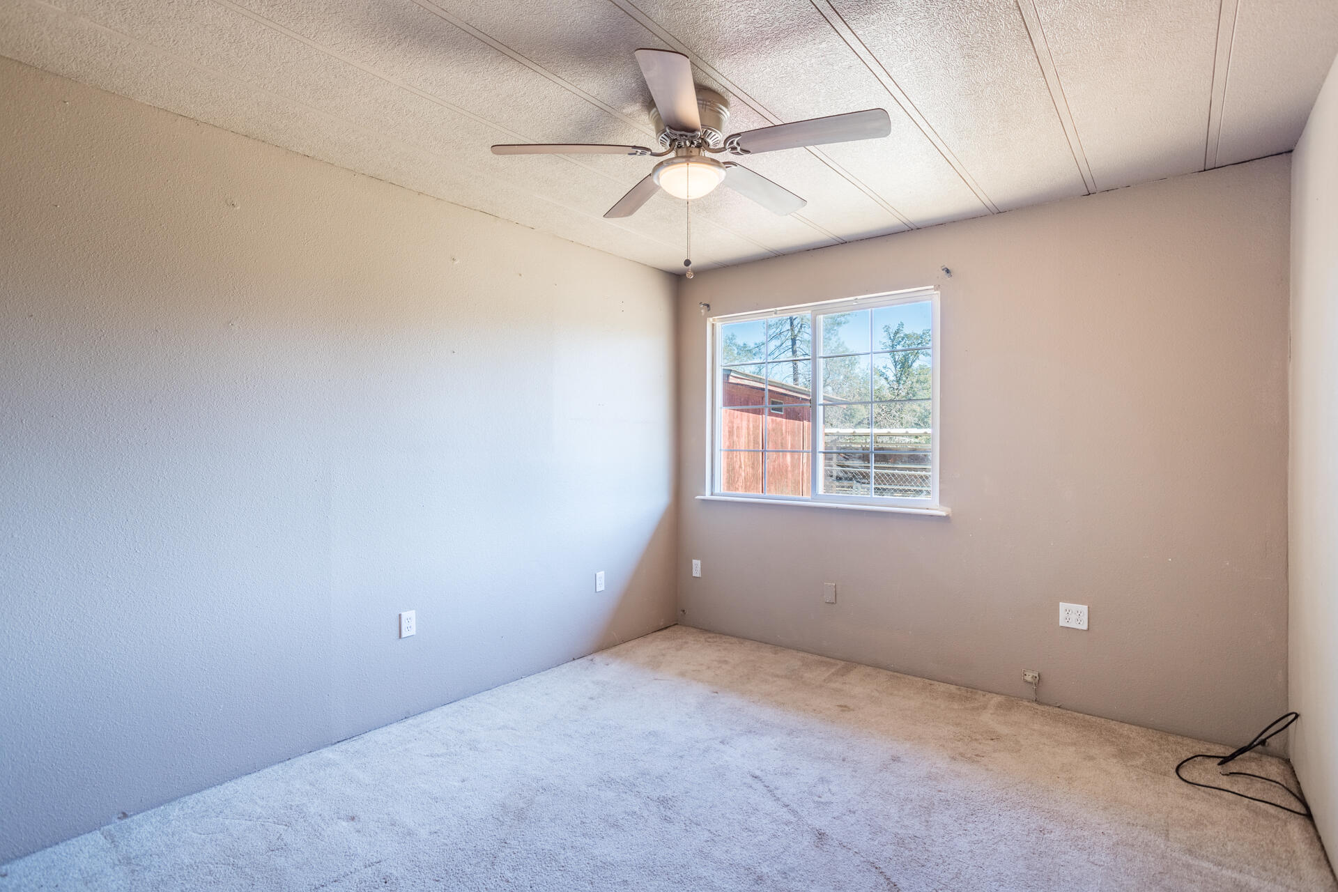 12141 Cinder Road Redding, CA 96003 - Photo 10 of 23 an empty room with a ceiling fan and window