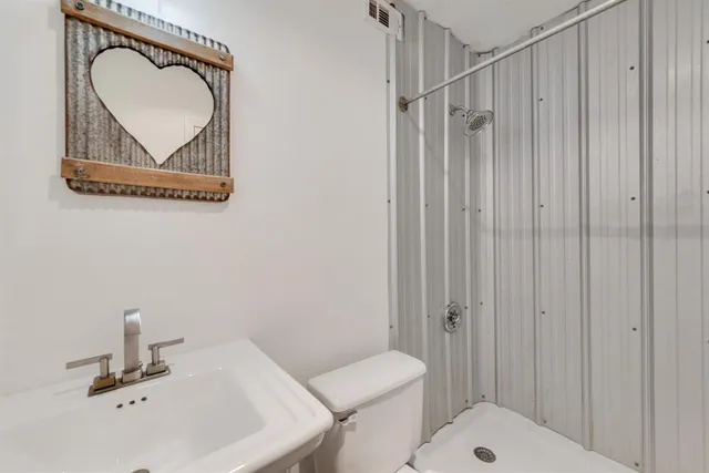 a bathroom with a sink a toilet and a mirror