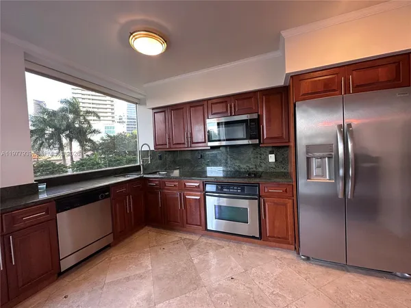 a kitchen with stainless steel appliances granite countertop a refrigerator a stove a sink and dishwasher
