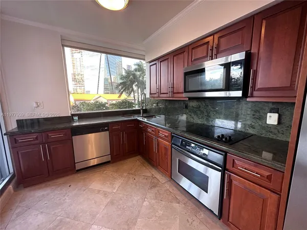 a kitchen with stainless steel appliances granite countertop a sink stove and microwave