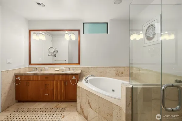 a bathroom with a tub sink and mirror