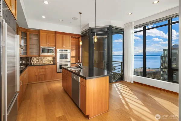 a kitchen with stainless steel appliances granite countertop a refrigerator a stove and a wooden floors