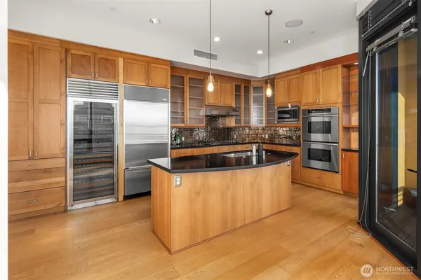a kitchen with stainless steel appliances granite countertop a sink and a refrigerator