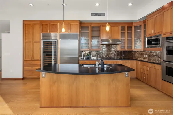 a kitchen with stainless steel appliances granite countertop a sink a stove and a refrigerator