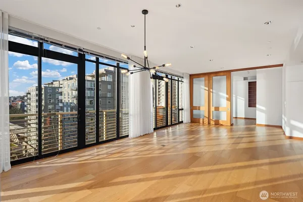 a view of an empty room with glass door and windows