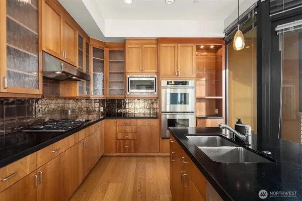a kitchen with stainless steel appliances granite countertop a sink and a stove