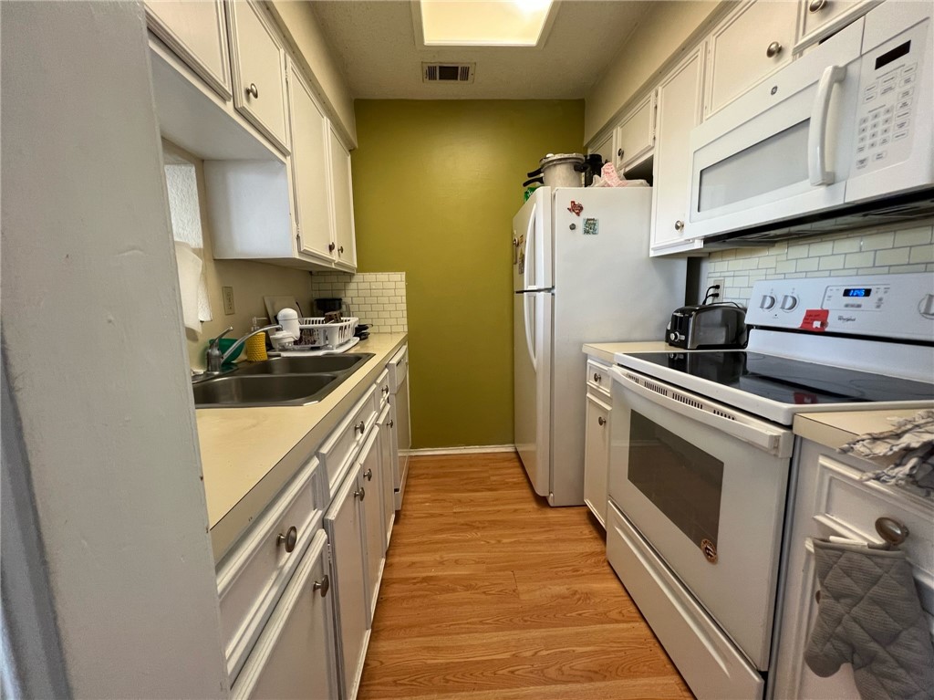 2706 Salado Street, Unit 302 Austin, TX 78705 - Photo 4 of 10 a kitchen with a sink a stove and cabinets